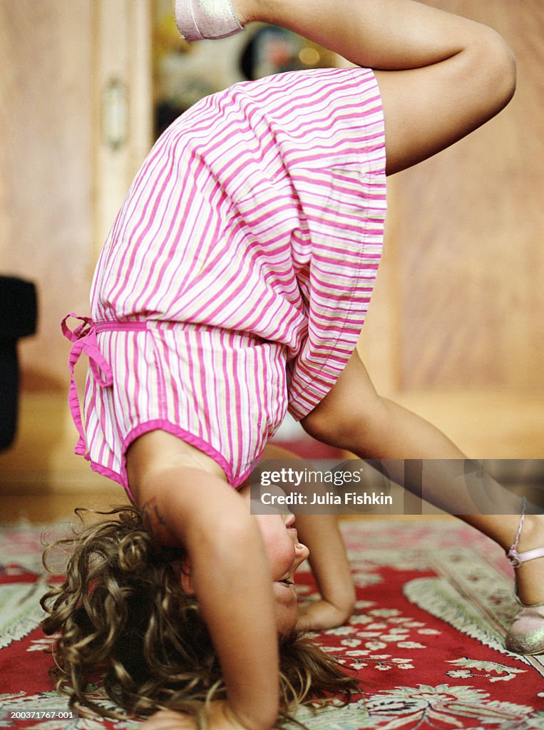 Girl (5-7) doing handstand, side view