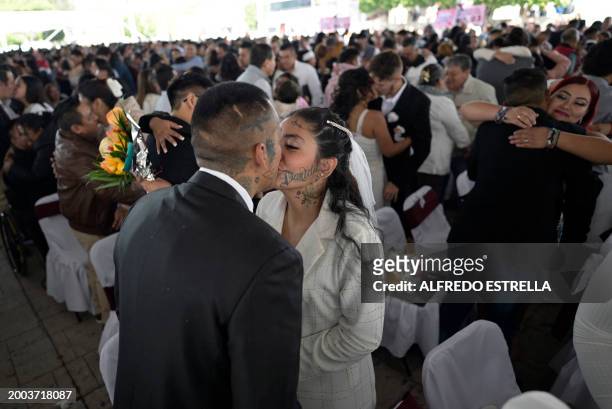 Couples kiss during a collective wedding celebration at the esplanade of the Municipal Palace of Nezahualcoyotl in Nezahualcoyotl, Mexico on February...