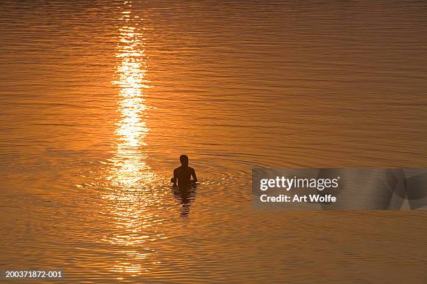 india, goa, swimmer silhouetted in water, elevated veiw - waist deep in water stock pictures, royalty-free photos & images