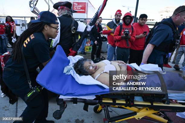 An injured person is taken to an ambulance near the Kansas City Chiefs' Super Bowl LVIII victory parade on February 14 in Kansas City, Missouri....