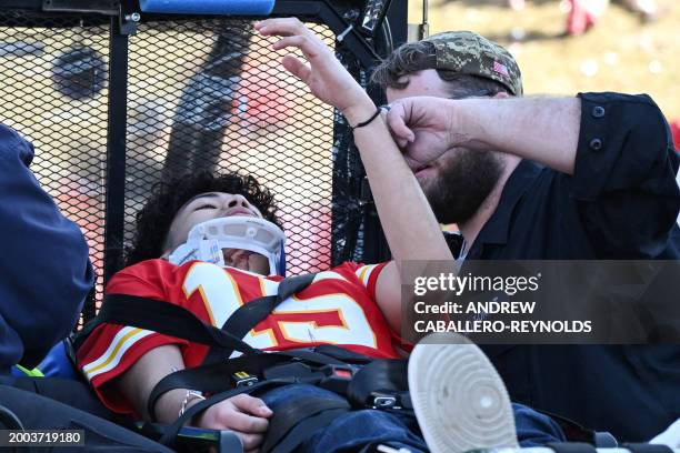 An injured person is aided near the Kansas City Chiefs' Super Bowl LVIII victory parade on February 14 in Kansas City, Missouri. Shots were...