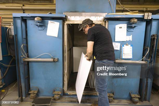 Worker removes a sheet of ABS plastic from a sheet dryer at the Usheco manufacturing facility in Kingston, New York, US, on Wednesday, Feb. 14, 2024....