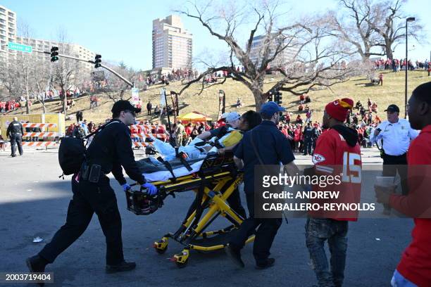 An injured person is aided by first responders near the Kansas City Chiefs' Super Bowl LVIII victory parade on February 14 in Kansas City, Missouri....