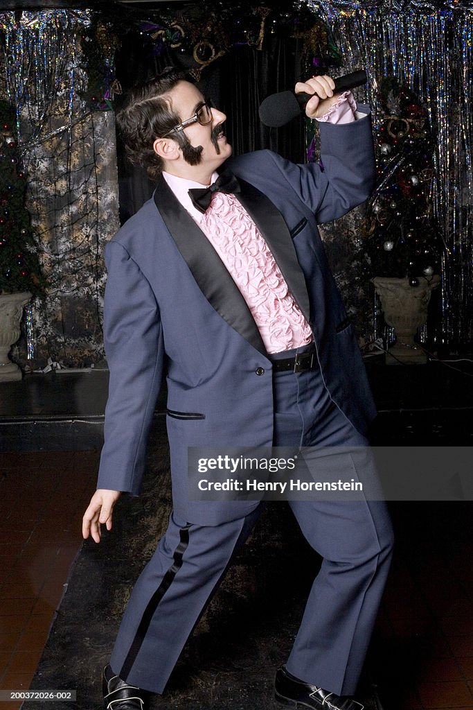 Female male impersonator singing on stage, side view