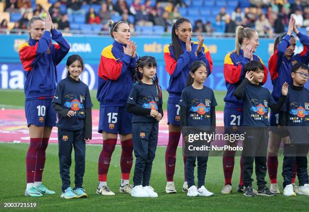 The FC Barcelona players are jumping onto the field with Chinese children to celebrate the Chinese New Year during the match between FC Barcelona and...