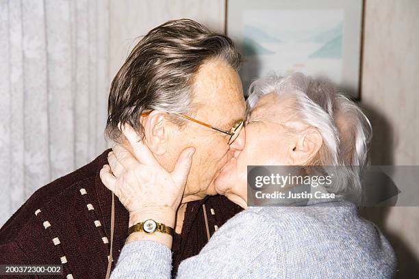 senior couple kissing, side view, close-up - peck stock pictures, royalty-free photos & images