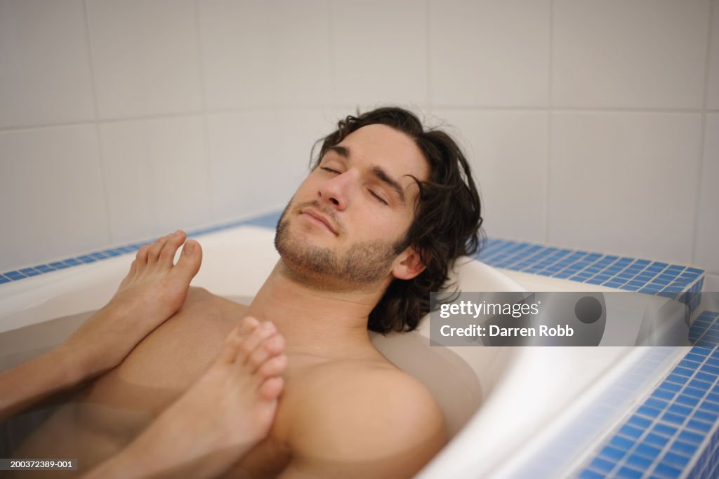 Young couple in bath, woman's feet on man's chest