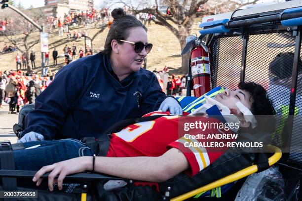 An injured person is aided near the Kansas City Chiefs' Super Bowl LVIII victory parade on February 14, 2024 in Kansas City, Missouri. One person was...
