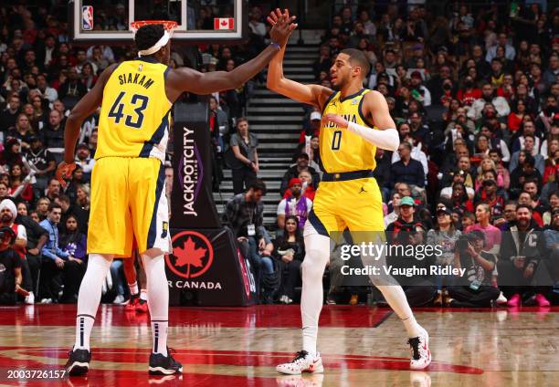 Pascal Siakam and Tyrese Haliburton of the Indiana Pacers high five during the game against the Toronto Raptors on February 14, 2024 at the...