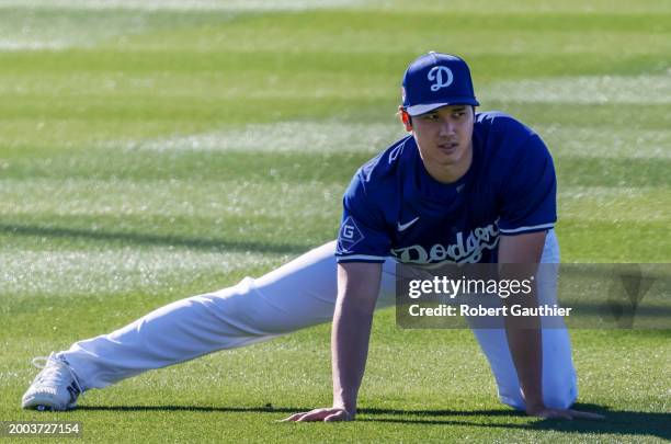 Goodyear, Arizona, Wednesday, February 14, 2024 - Bearing the scar of Tommy John surgery, Shohei Ohtani stretches at the LA Dodgers first official...