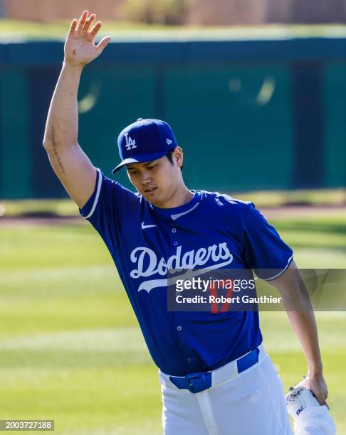 Goodyear, Arizona, Wednesday, February 14, 2024 - Bearing the scar of Tommy John surgery, Shohei Ohtani stretches at the LA Dodgers first official...