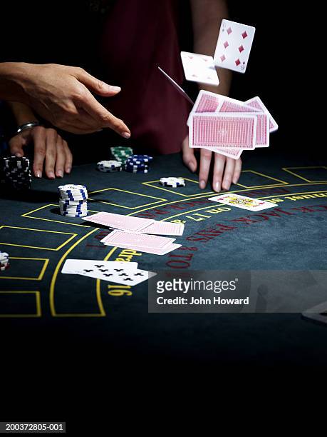 woman throwing cards onto gaming table, close-up - casino tables hands stock pictures, royalty-free photos & images