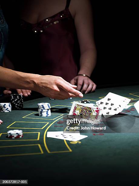 woman throwing cards on gaming table, close-up - casino interior photos et images de collection