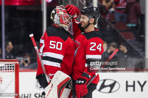 New Jersey Devils goaltender Nico Daws celebrates with New Jersey Devils defenseman Colin Miller after winning a game between the Seattle Kraken and...