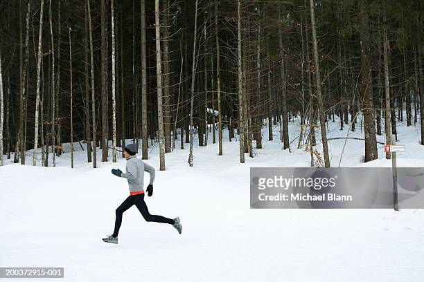 Man running on snow, side view