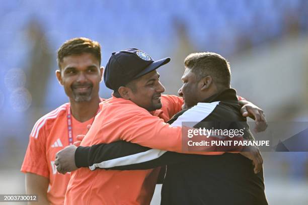 India's Sarfaraz Khan greets his father before his debut match at the Niranjan Shah stadium formerly known as Saurashtra Cricket Association in...