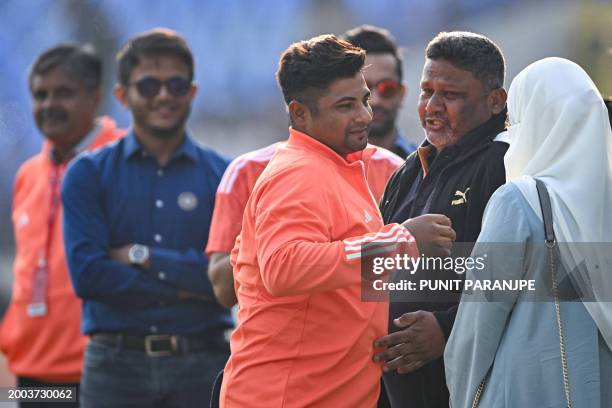 India's Sarfaraz Khan greets his father before his debut match at the Niranjan Shah stadium formerly known as Saurashtra Cricket Association in...