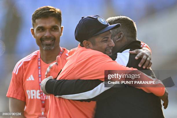 India's Sarfaraz Khan greets his father before his debut match at the Niranjan Shah stadium formerly known as Saurashtra Cricket Association in...