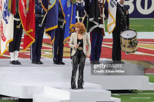 Reba McEntire sings the United States national anthem before Super Bowl LVIII between the San Francisco 49ers and the Kansas City Chiefs at Allegiant...