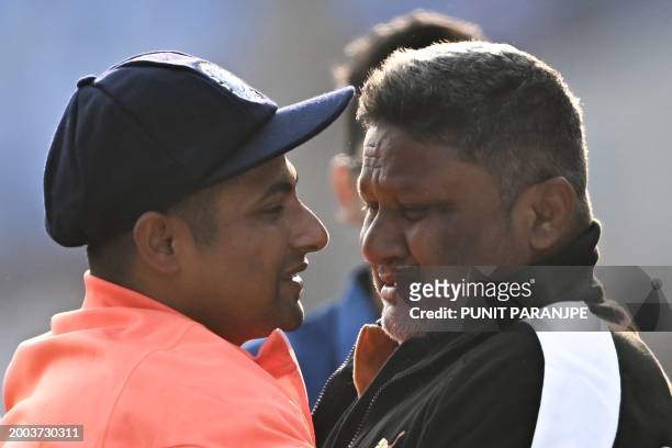 India's Sarfaraz Khan greets his father before his debut match at the Niranjan Shah stadium formerly known as Saurashtra Cricket Association in...