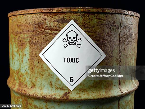 rusty oil drum with toxic label, close-up - nocivo descripción física fotografías e imágenes de stock