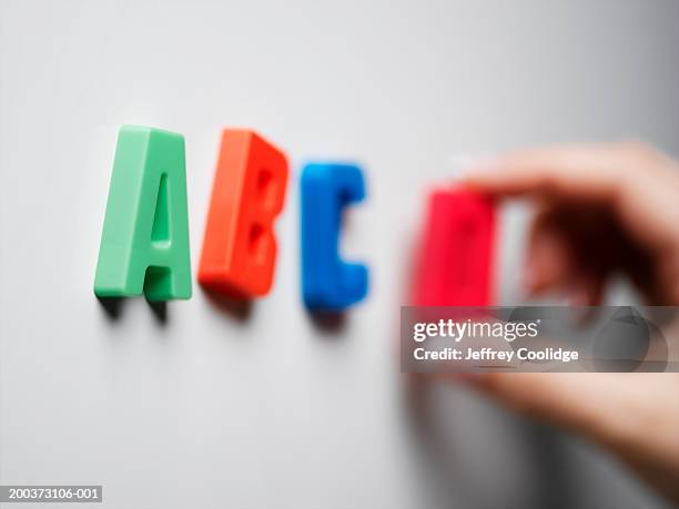 woman placing magnetic letters on board, close-up - abc stock pictures, royalty-free photos & images