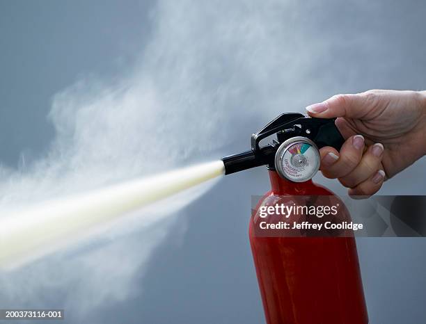 woman using fire extinguisher, close-up - extinguishing stock pictures, royalty-free photos & images