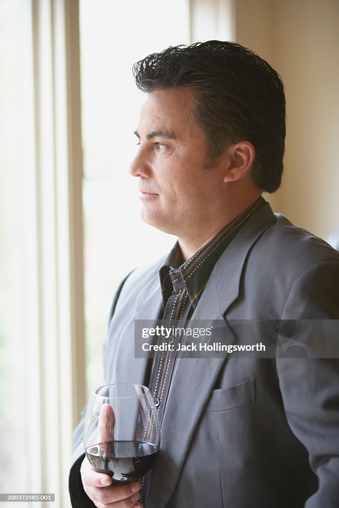 Side profile of a mid adult man looking out of a window