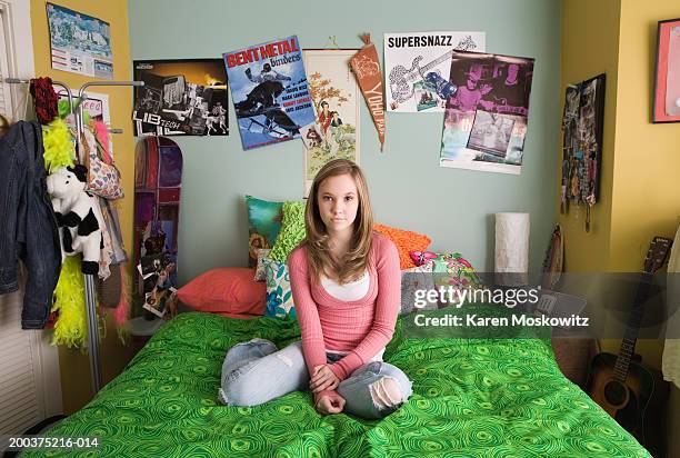 teenage girl (14-16) sitting on bed, portrait - teen girl 15 sitting fotografías e imágenes de stock