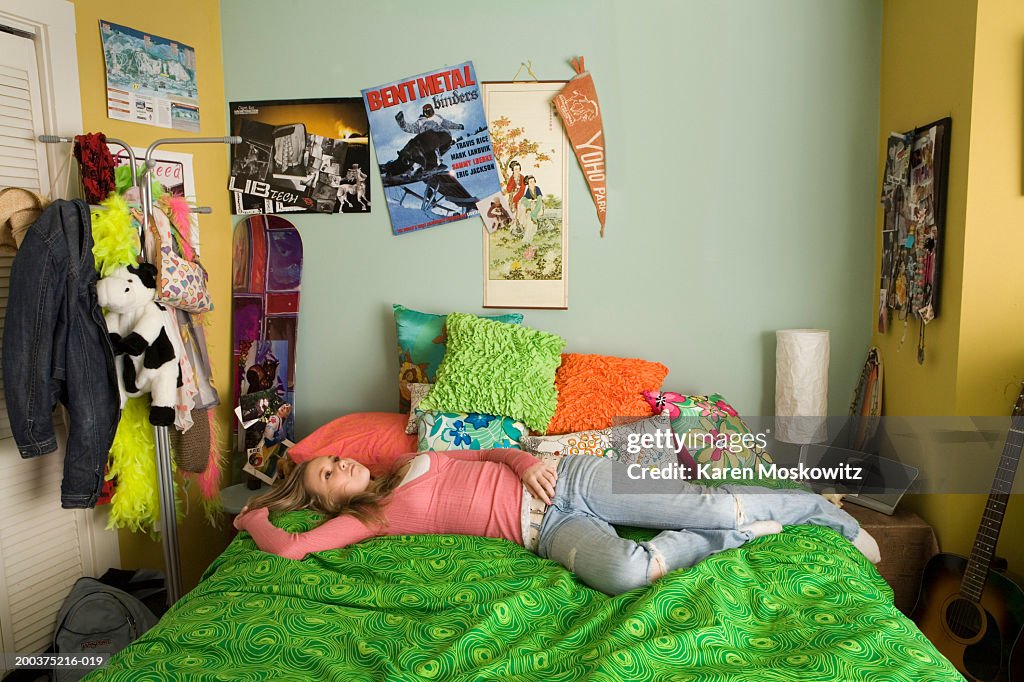 Teenage girl (14-16) lying on bed, staring at ceiling, elevated view