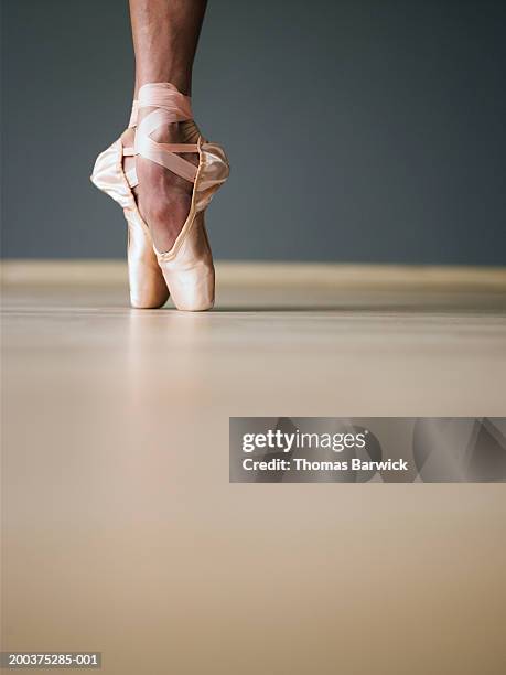 young female ballerina standing on toes, ground view - human foot stockfoto's en -beelden