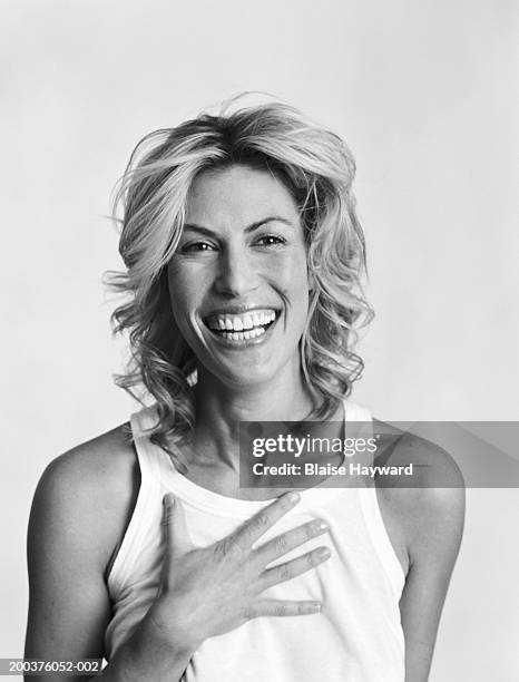 woman laughing, holding hand to chest (b&w) - blanco y negro fotografías e imágenes de stock