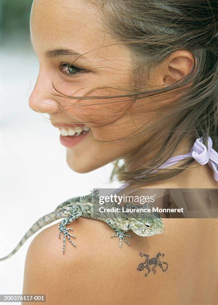 girl (12-14) with lizard on shoulder beside tattoo, smiling, close-up - 12 13 girl closeup stock pictures, royalty-free photos & images