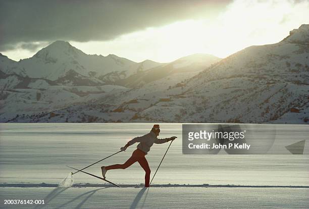 man cross country skiing, side view - ski pants stock-fotos und bilder