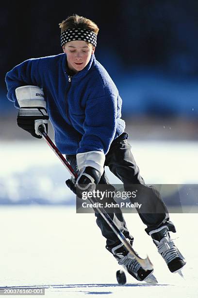 teenage boy (13-15) playing hockey outdoors - outdoor ice hockey stock pictures, royalty-free photos & images