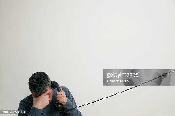 man sitting on stairs using telephone, hand to forehead - frustrated on phone stock pictures, royalty-free photos & images