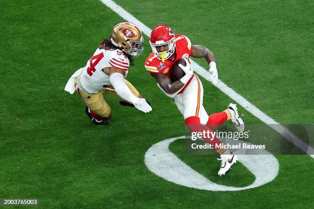 Jerick McKinnon of the Kansas City Chiefs runs the ball against Fred Warner of the San Francisco 49ers in the first quarter during Super Bowl LVIII...