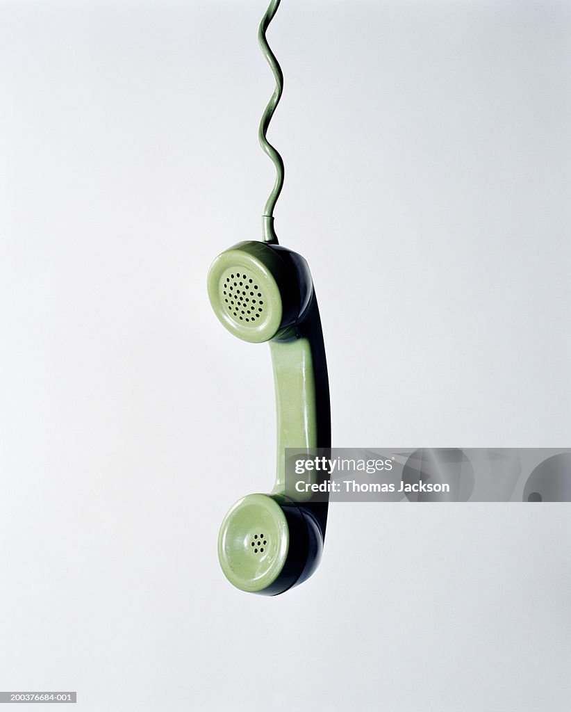 Retro green telephone receiver with cord extended