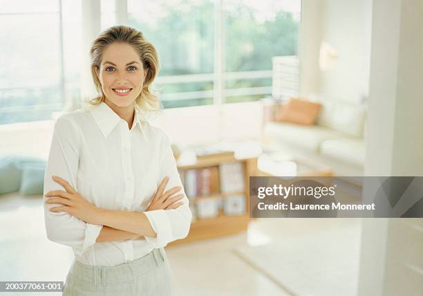 woman in apartment with arms crossed smiling, portrait - offener kragen stock-fotos und bilder