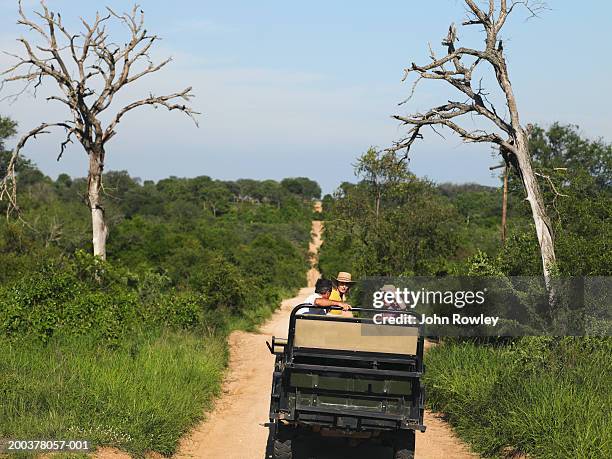 two couples on safari sitting in 4x4 on track - 車　子供　アフリカ ストックフォトと画像