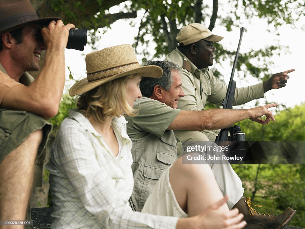 Senior man and couple on safari with guide, smiling