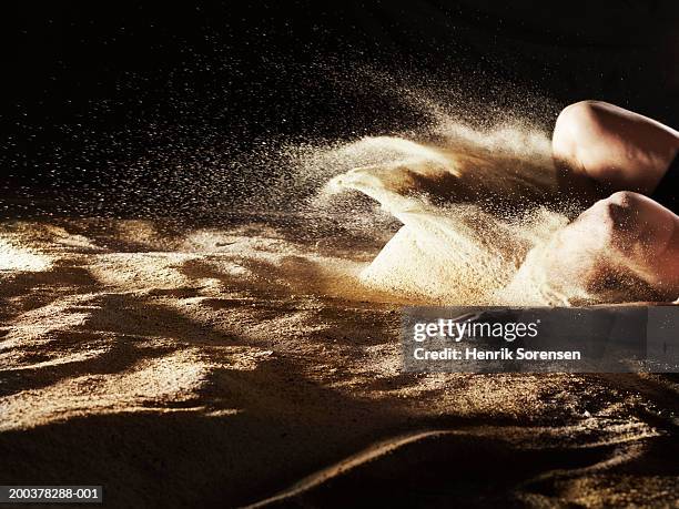 male athlete landing in sand, low section - weitsprung stock-fotos und bilder