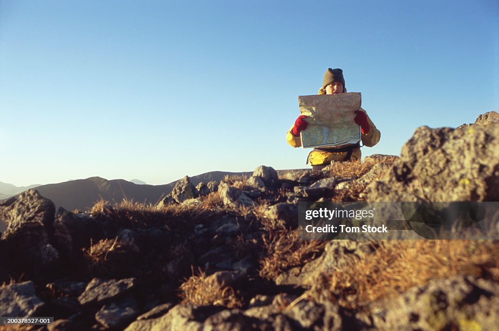 Mature man reading map on mountain