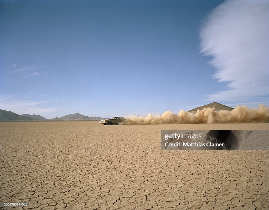 Car racing through desert, side view