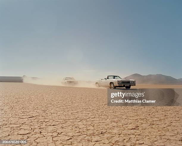 car chasing convertible in desert - chasing stock-fotos und bilder