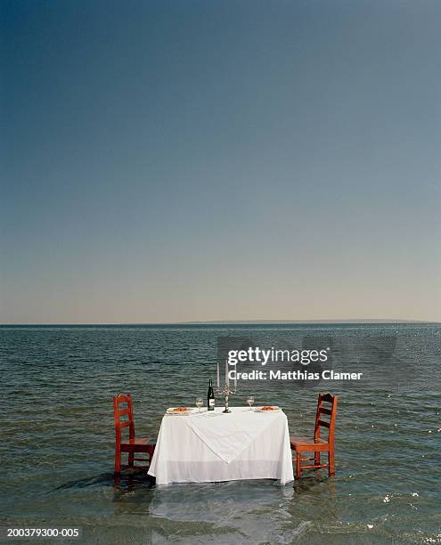 dinner table in middle ocean, side view - unexpected stock pictures, royalty-free photos & images