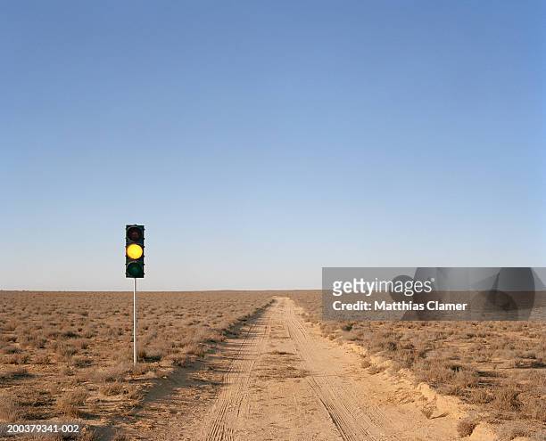 yellow traffic light on desert road - amber light stock pictures, royalty-free photos & images