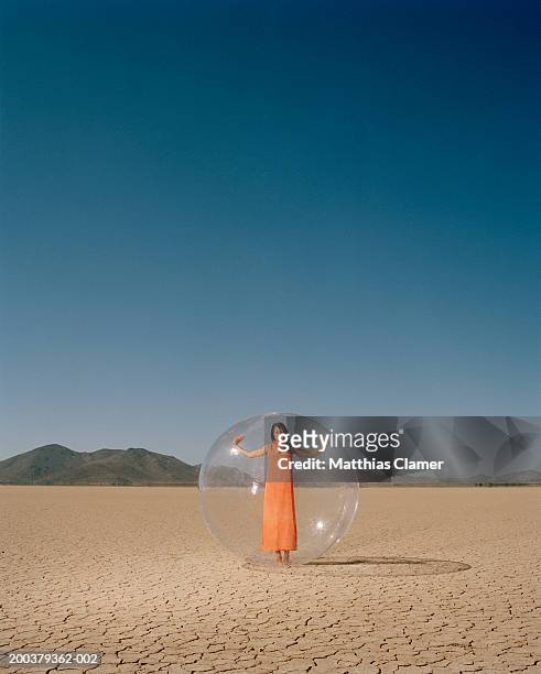 young woman in desert standing in plastic bubble, portrait - transparent plastic stock pictures, royalty-free photos & images