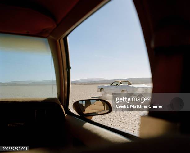 two cars racing in desert, close-up - pursuit stock-fotos und bilder