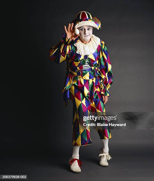 senior clown holding egg, portrait - chapeau de bouffon photos et images de collection